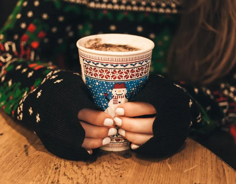 Hands wrapped around a festive mug