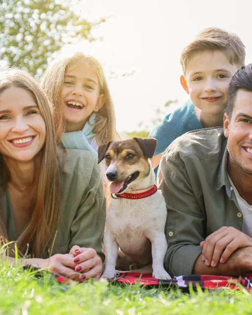 A family lying on the grass with their dog